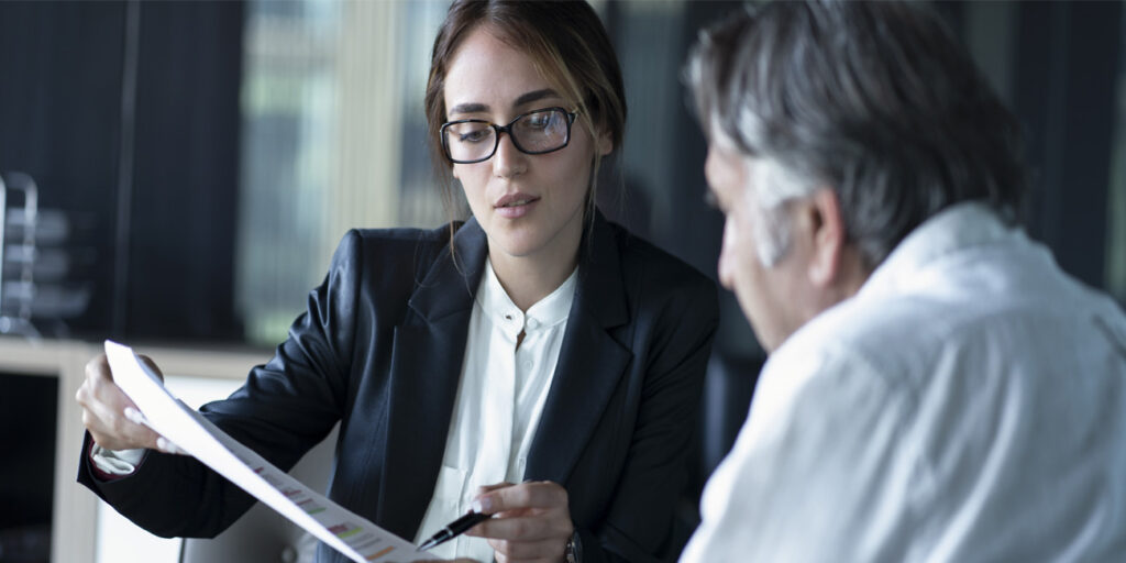 Two business professional carefully checking payroll numbers